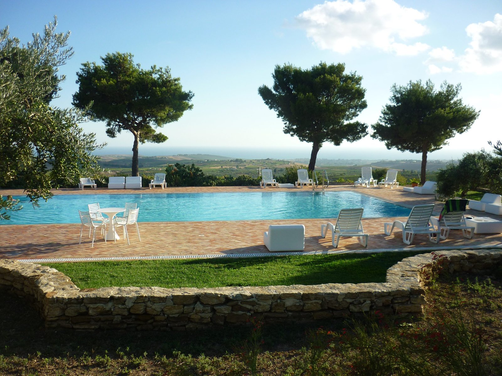 Infinity pool and umbrella pines at a Sicilian estate